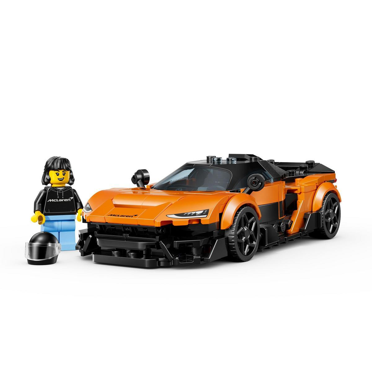 Model samochodu Lego McLaren i minifigurka z kaskiem. Samochód jest pomarańczowo-czarny. Minifigurka ma czarną kurtkę.