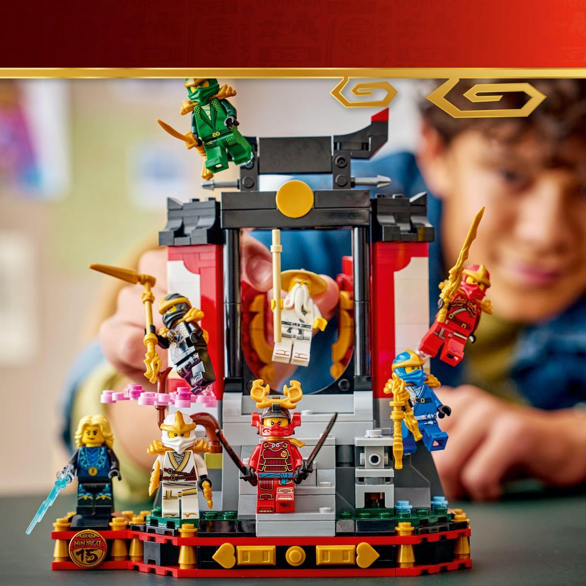 Zestaw Lego Ninjago z kilkoma figurkami ninja z bronią i konstrukcją świątyni, trzymany przez osobę.