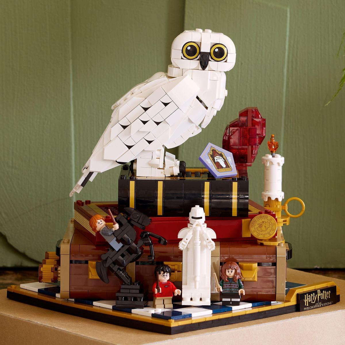 Zestaw Lego Harry Potter. Duża biała sowa siedzi na książkach. Minifigurki to Harry, Ron i Hermiona.