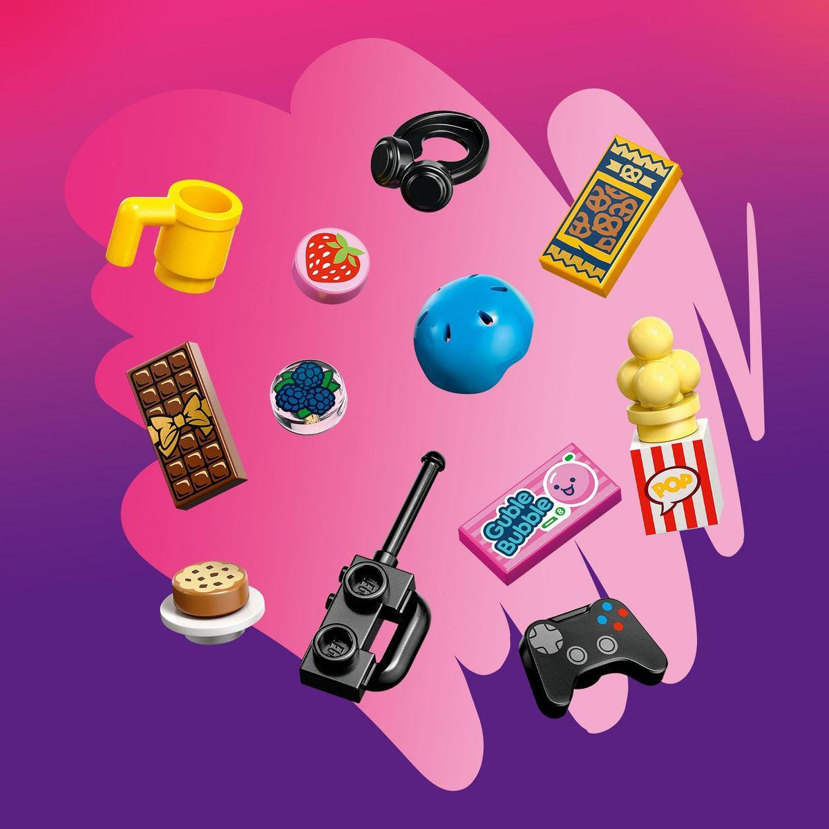 L'immagine mostra giocattoli in miniatura: cuffie, popcorn, barretta di cioccolato, biscotto, controller, casco, gomma e bacche.