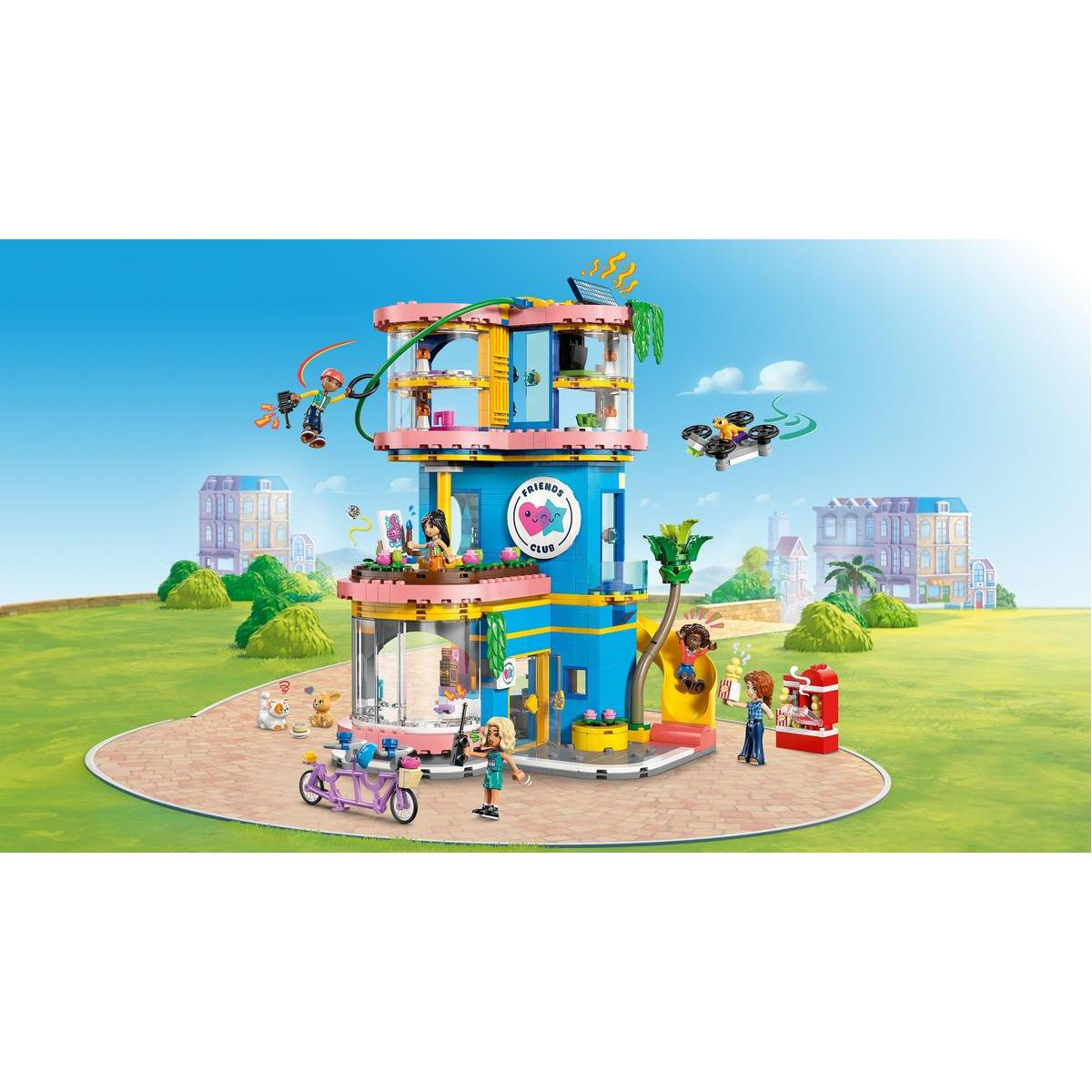 Un colorato set LEGO Friends. Un edificio a più piani con personaggi e accessori. Un cielo blu e un paesaggio verde sullo sfondo.