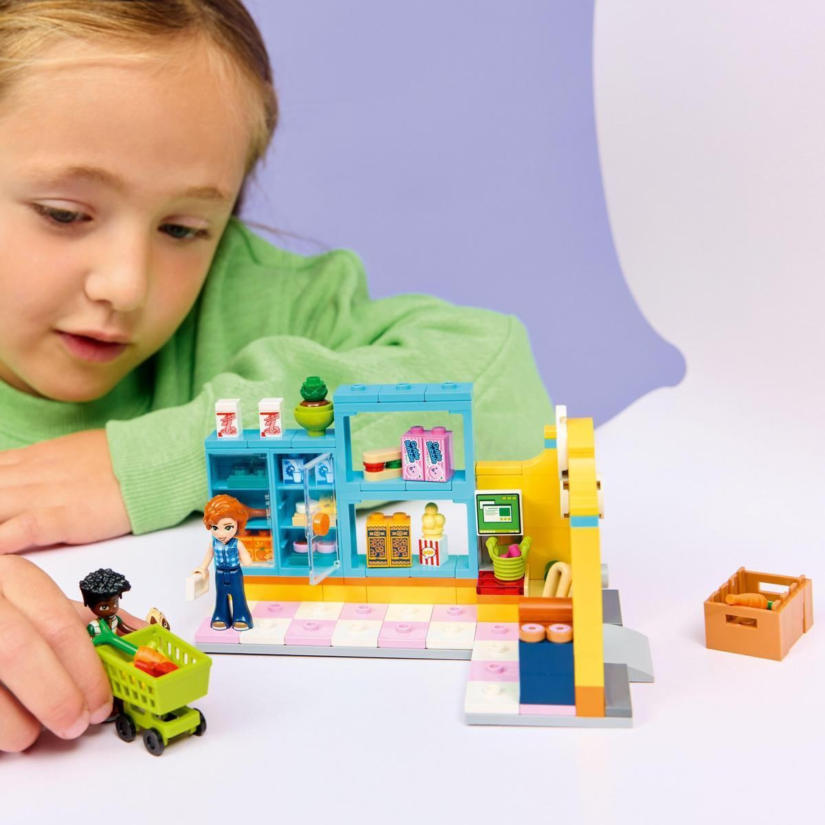 Bir kız, Lego markete bakıyor. Lego figürleri bir arabayla alışveriş yapıyor. Mağazada yiyecek ve bir yazar kasa var. Bir sandıkta havuç var.