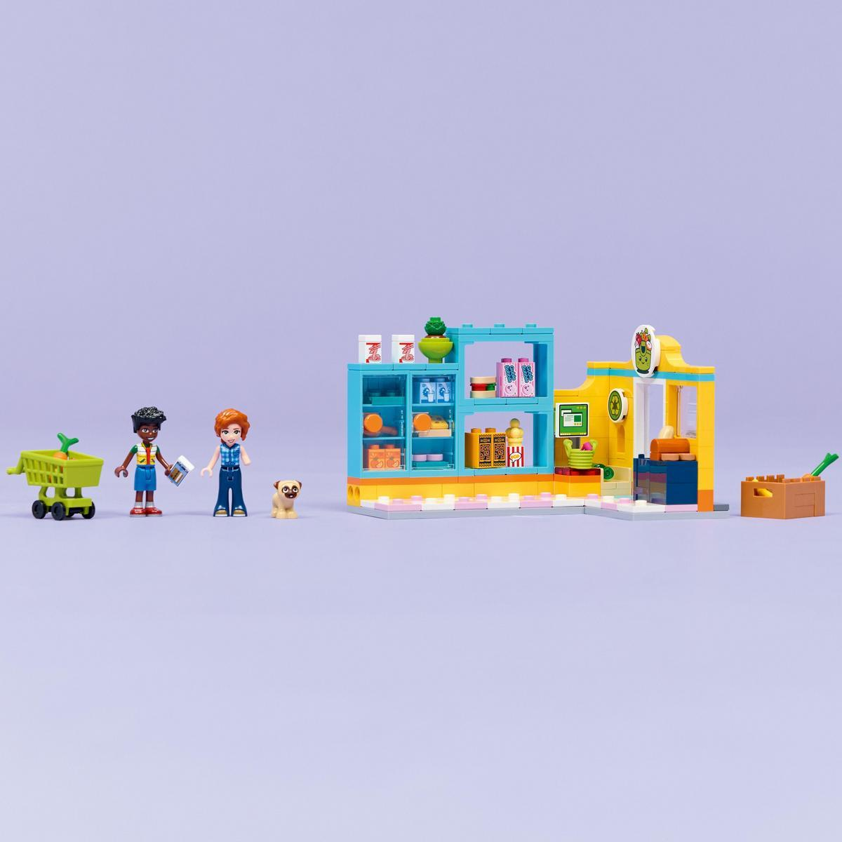 Lego market sahnesi. Figürler, alışveriş arabası, köpek, ürün rafları ve sarı cepheli bir bina içerir.