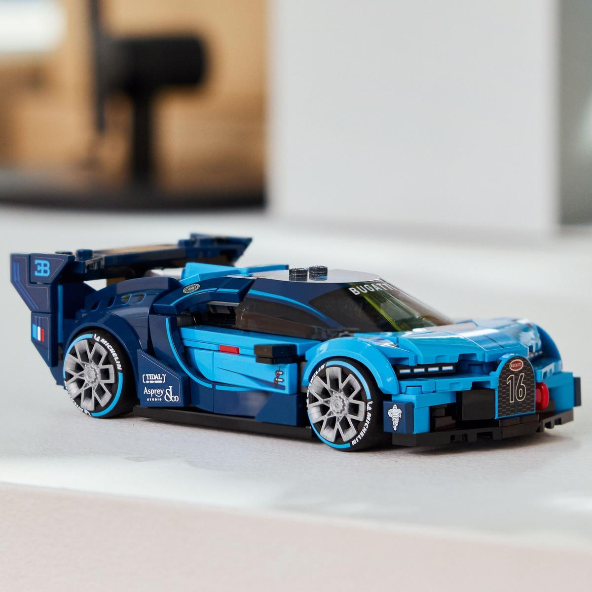 Niebieski samochód wyścigowy Lego Bugatti na białej powierzchni. Ma spojler, numer 16 i logo Bugatti.