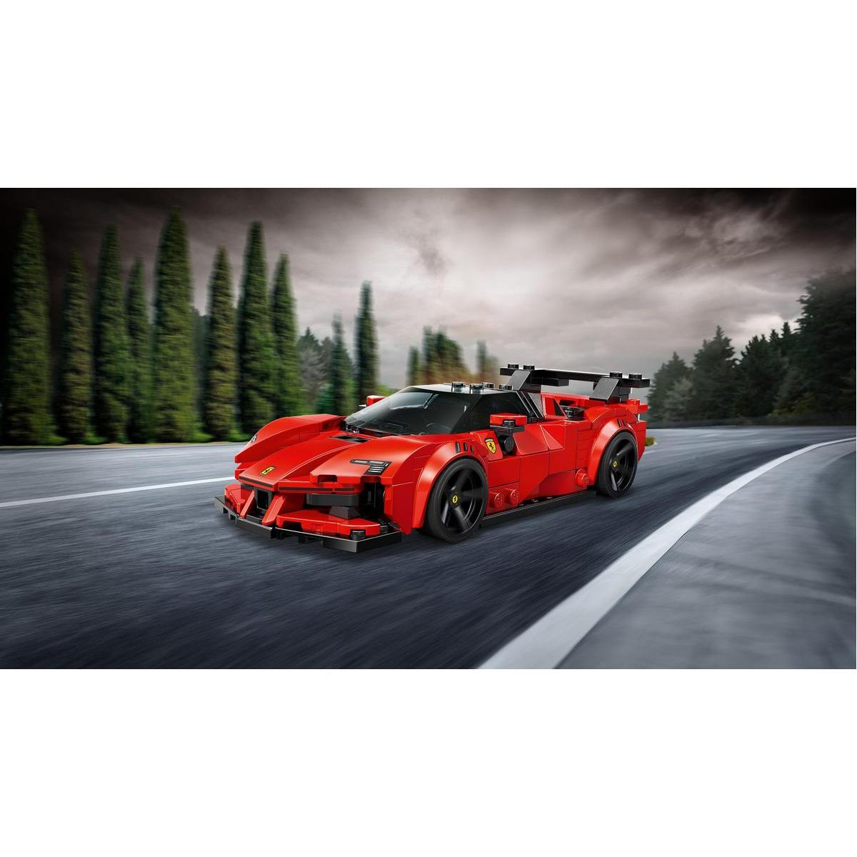 Czerwony samochód sportowy Lego Ferrari jedzie po drodze. Drzewa rosną wzdłuż drogi. Niebo jest pochmurne.