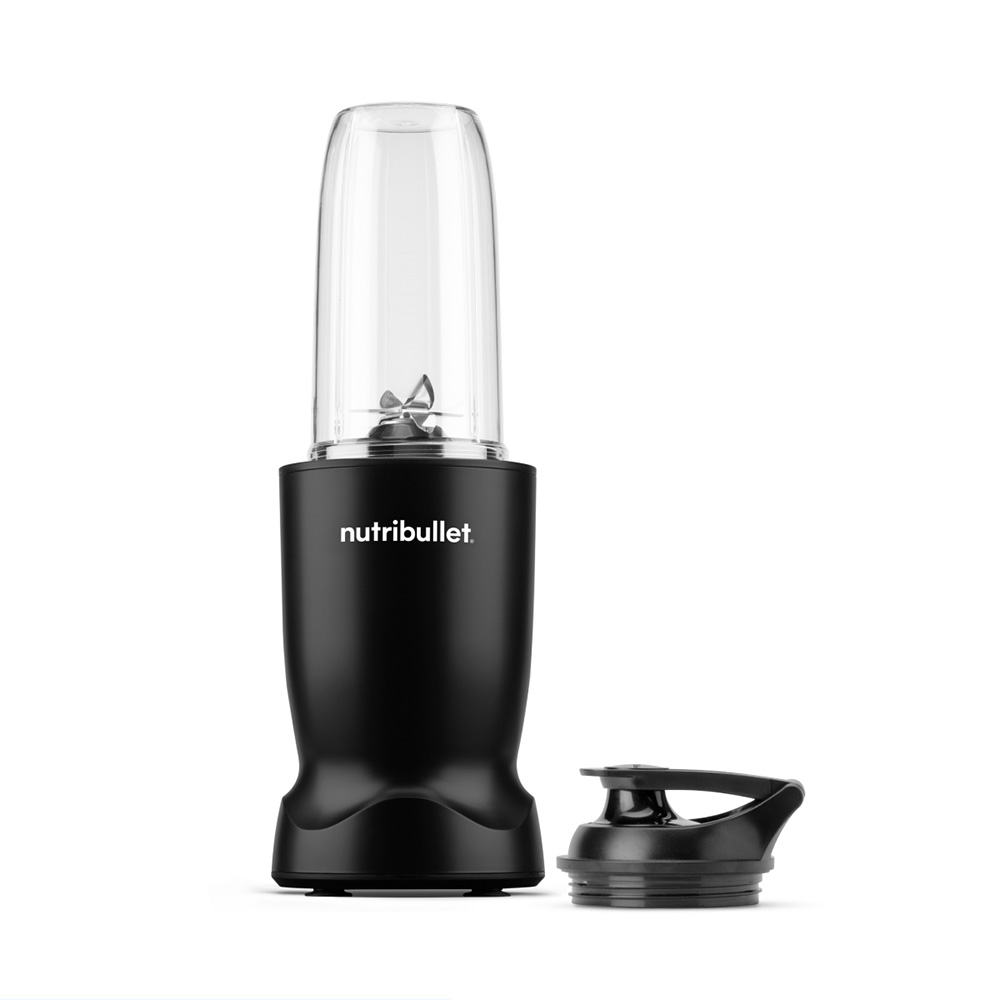 Een zwarte Nutribullet-blender met een doorzichtige container. Het deksel ligt rechts. Witte achtergrond.
