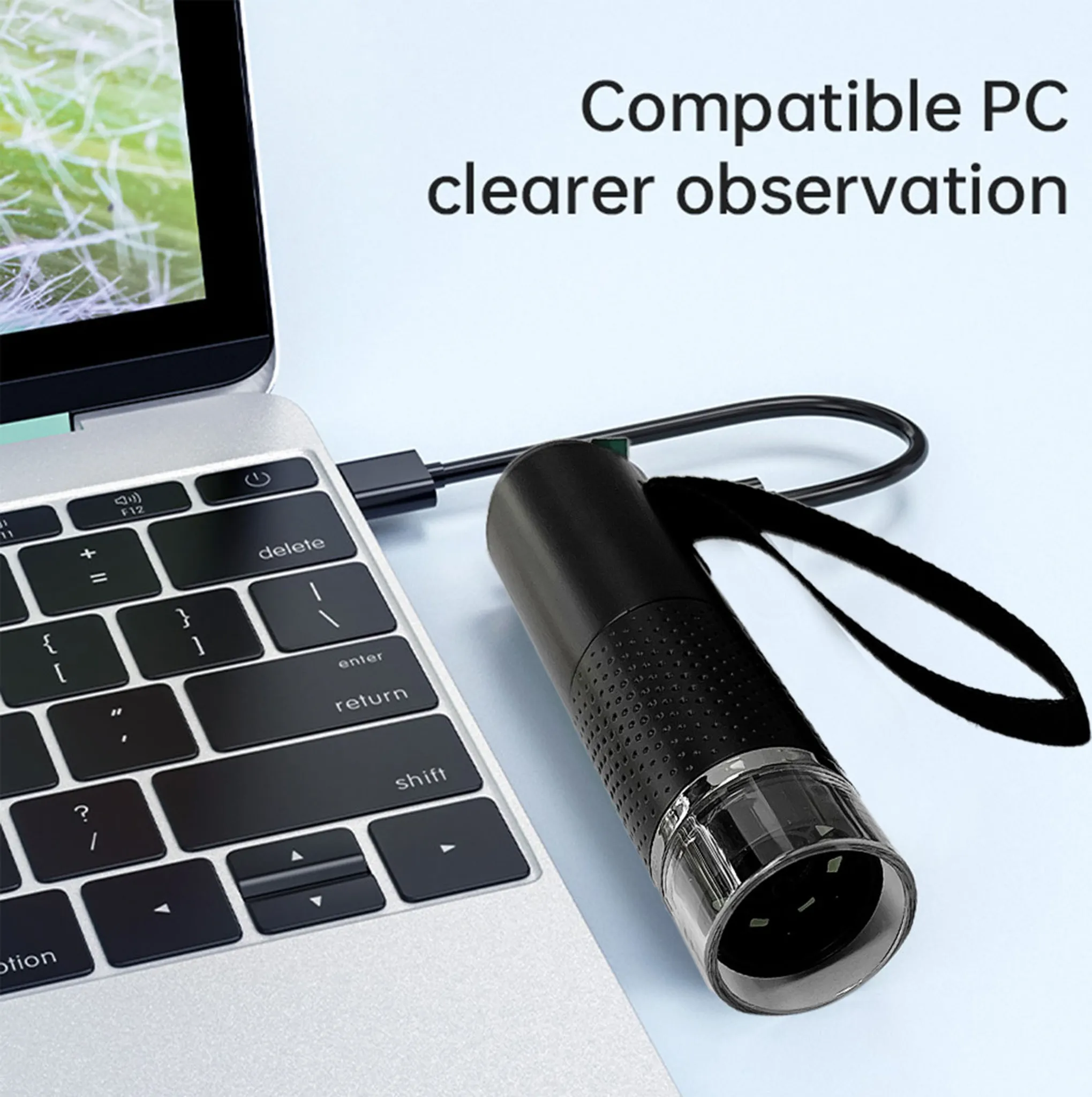 Ein schwarzes Mikroskop, das über ein USB-Kabel mit einem Laptop verbunden ist, Text lautet 'Kompatibler PC klarere Beobachtung'.