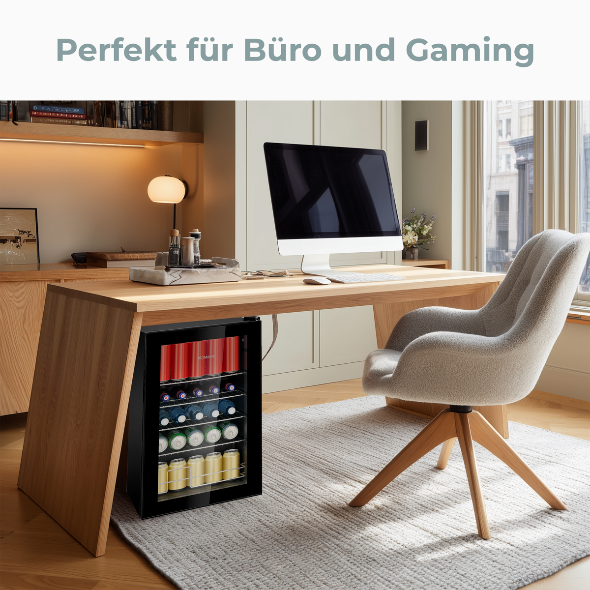 Moderne Büroeinrichtung mit Schreibtisch, Computer und Minikühlschrank. Ein bequemer Stuhl und ein Fenster sind sichtbar.