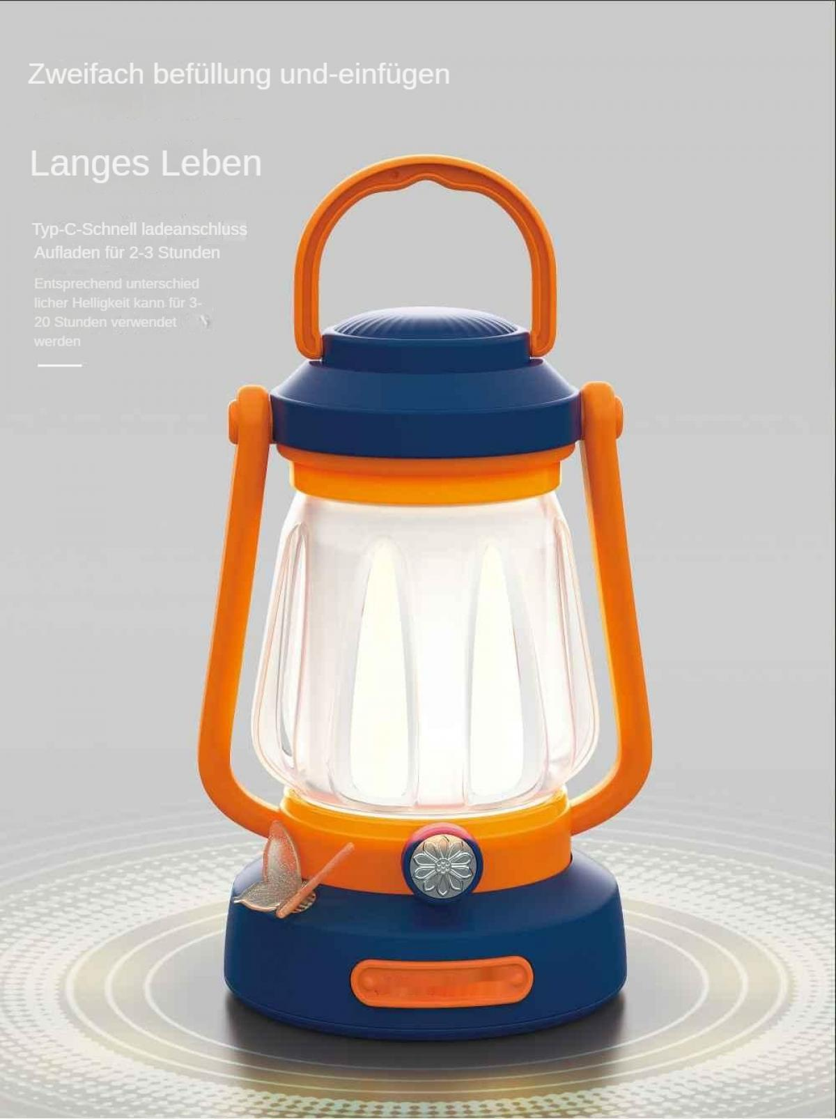 Eine blau-orangefarbene Laterne steht auf einer grauen Oberfläche. Sie hat einen Griff und ist innen beleuchtet. Ein Schmetterling ist an der Basis.