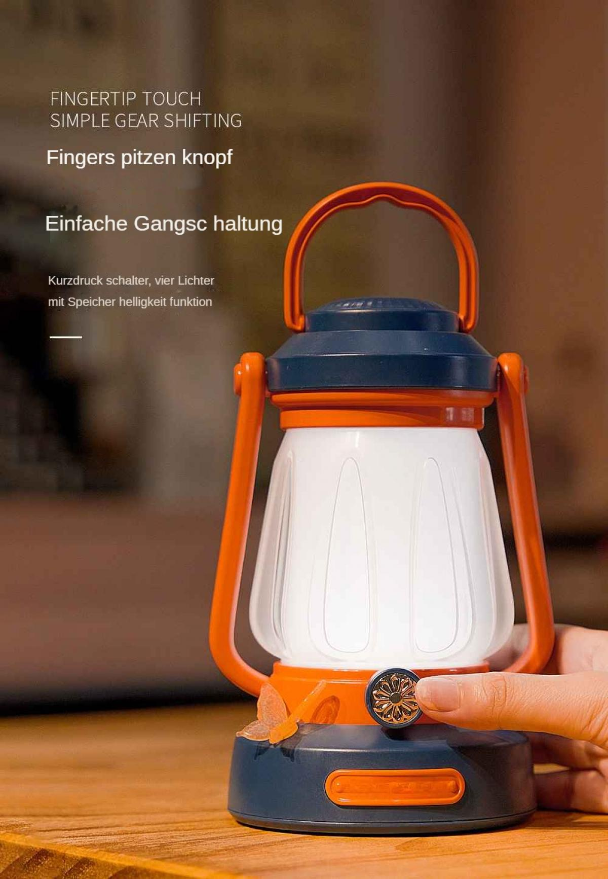 Eine orangefarbene und marineblaue Laterne steht auf einer Holzoberfläche. Eine Hand berührt einen Knopf an der Laterne. Die Laterne hat einen Griff.