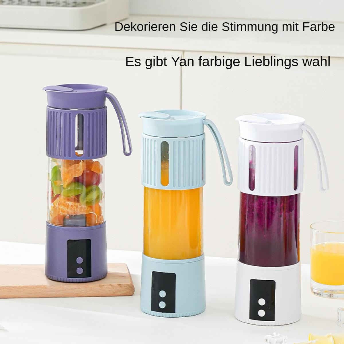 Drei bunte, tragbare Mixer, einer lila mit Obst, einer blau mit orangener Flüssigkeit und einer weiß mit roter Flüssigkeit.