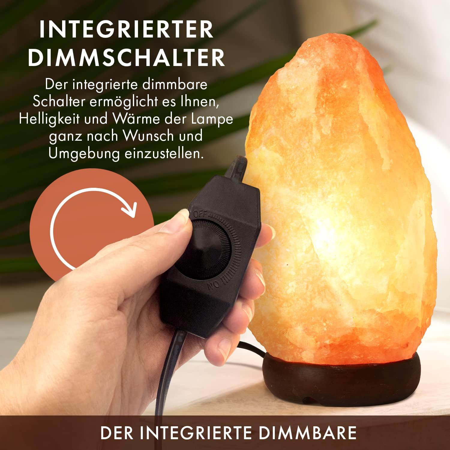 Eine Hand stellt einen schwarzen Dimmschalter ein, der mit einer orangefarbenen Salzlampe verbunden ist. Die Lampe steht auf einem dunkelbraunen Sockel.