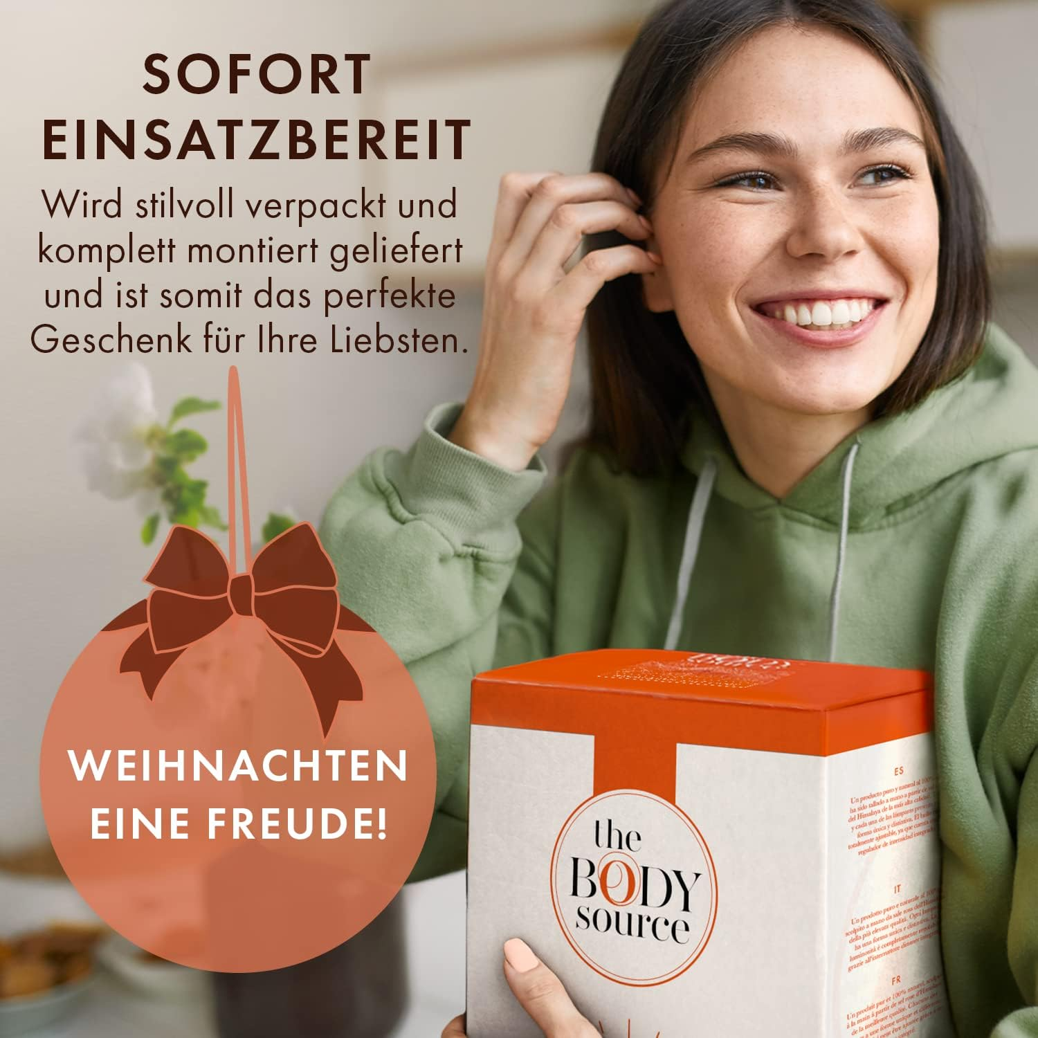 Lächelnde Frau hält eine Geschenkbox. Text lautet 'SOFORT EINSATZBEREIT' und 'WEIHNACHTEN EINE FREUDE!'. Ein Weihnachtsschmuck ist sichtbar.