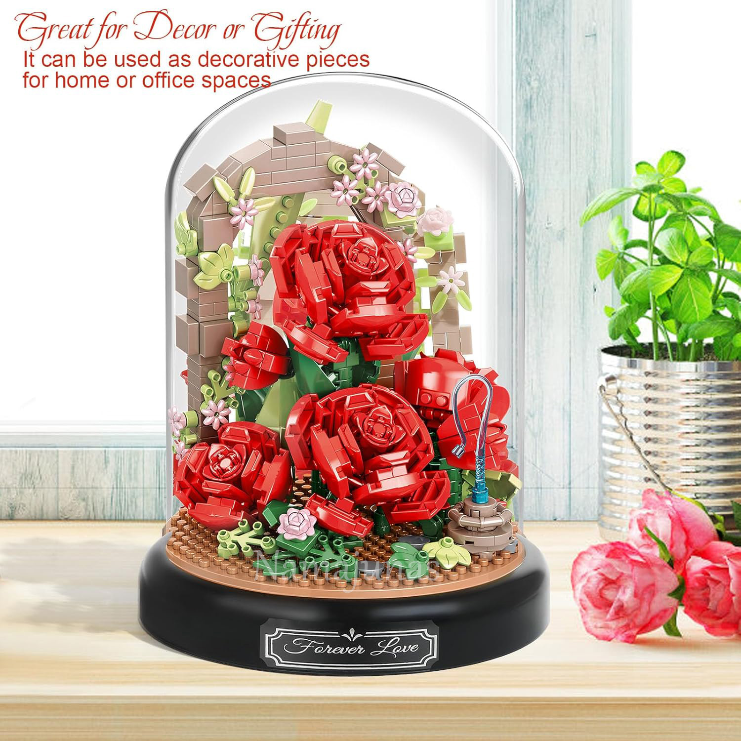 Eine dekorative Glaskuppel zeigt rote Lego-Rosen, einen Backsteinmauer-Hintergrund und eine Basis mit der Aufschrift 'Forever Love'. Eine Pflanze steht daneben.