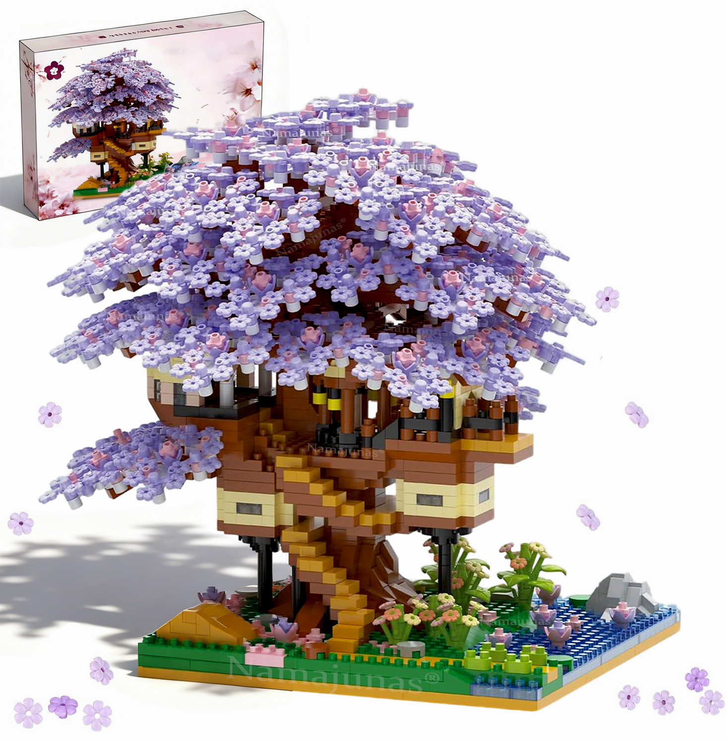 Ein Baumhausmodell aus Blöcken mit lila Blüten am Baum. Es steht auf einer grünen Basis mit Wasser und Blumen.