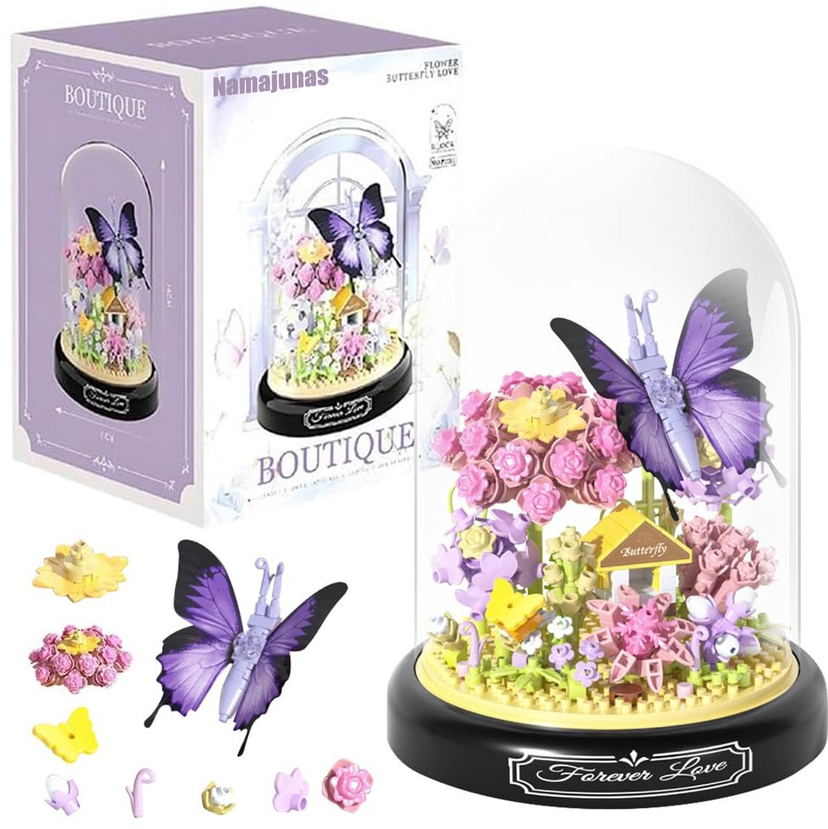 Ein Schmetterlings-Diorama mit Haus, Blumen und einer Schmetterlingsfigur unter einer Glaskuppel. Es hat eine Box links.