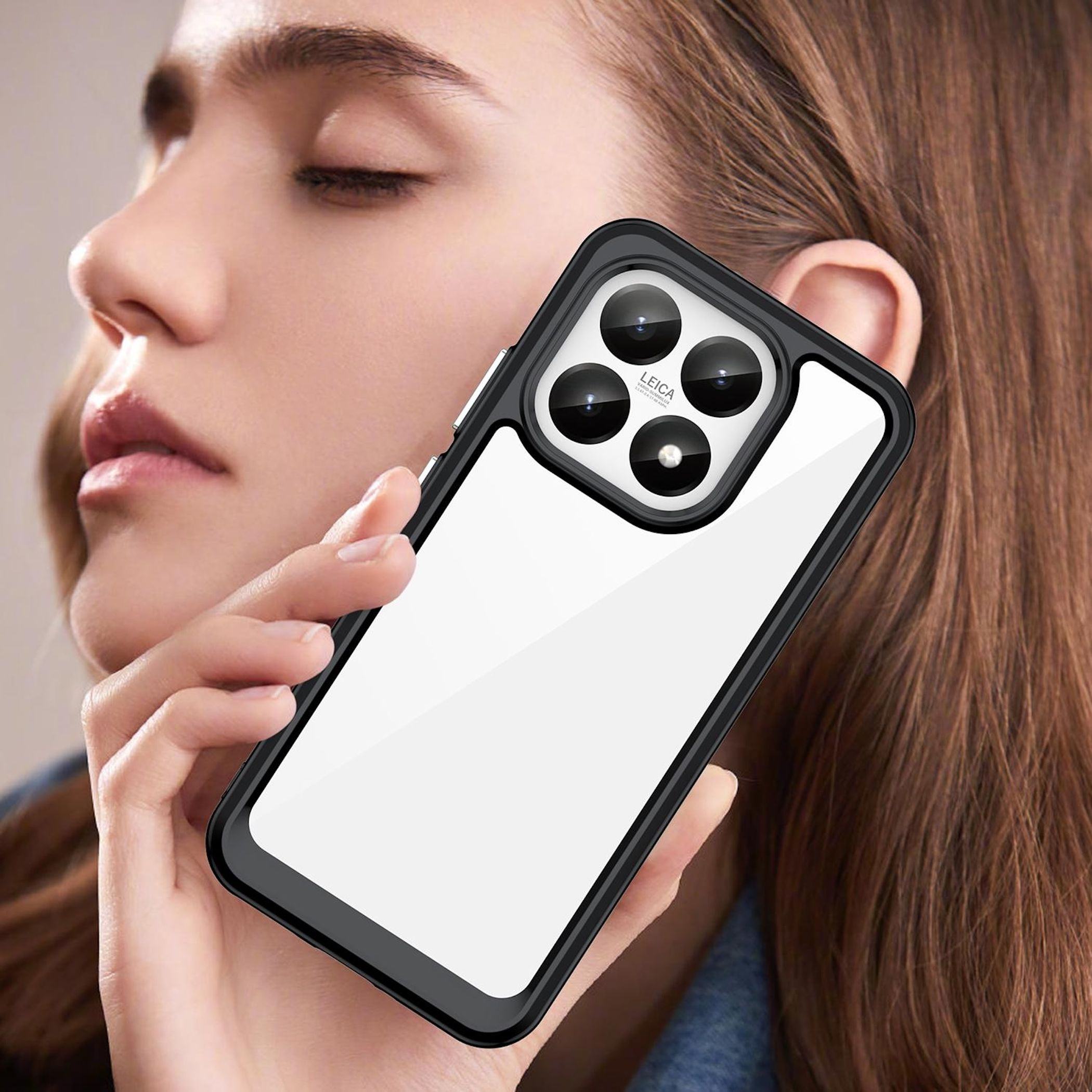 Una mujer sostiene un teléfono en una funda negra. El teléfono tiene una cámara Leica. La mujer tiene los ojos cerrados y cabello castaño.