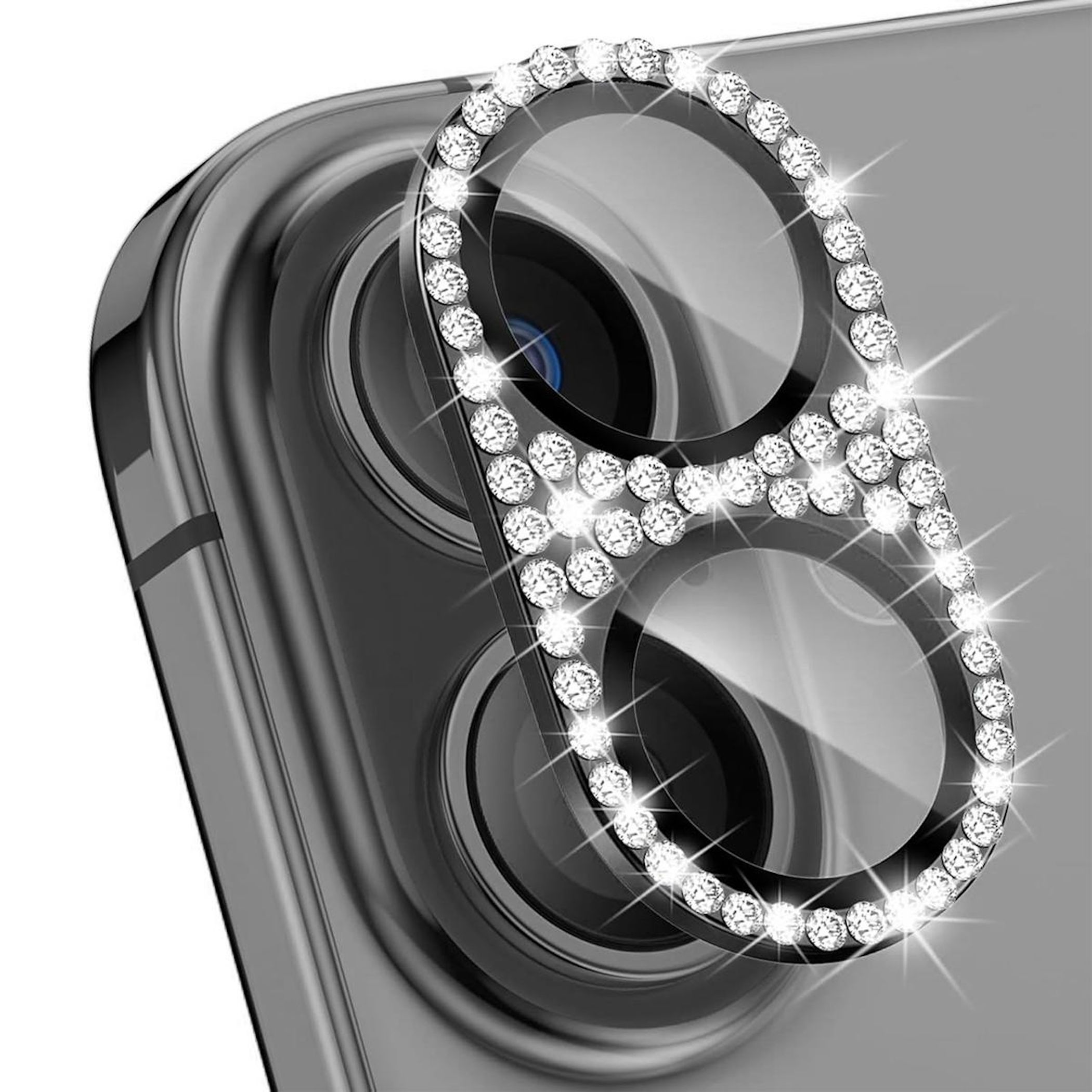 Un proteggi obiettivo della fotocamera del telefono con pietre a forma di diamante. Le lenti della fotocamera del telefono sono visibili.