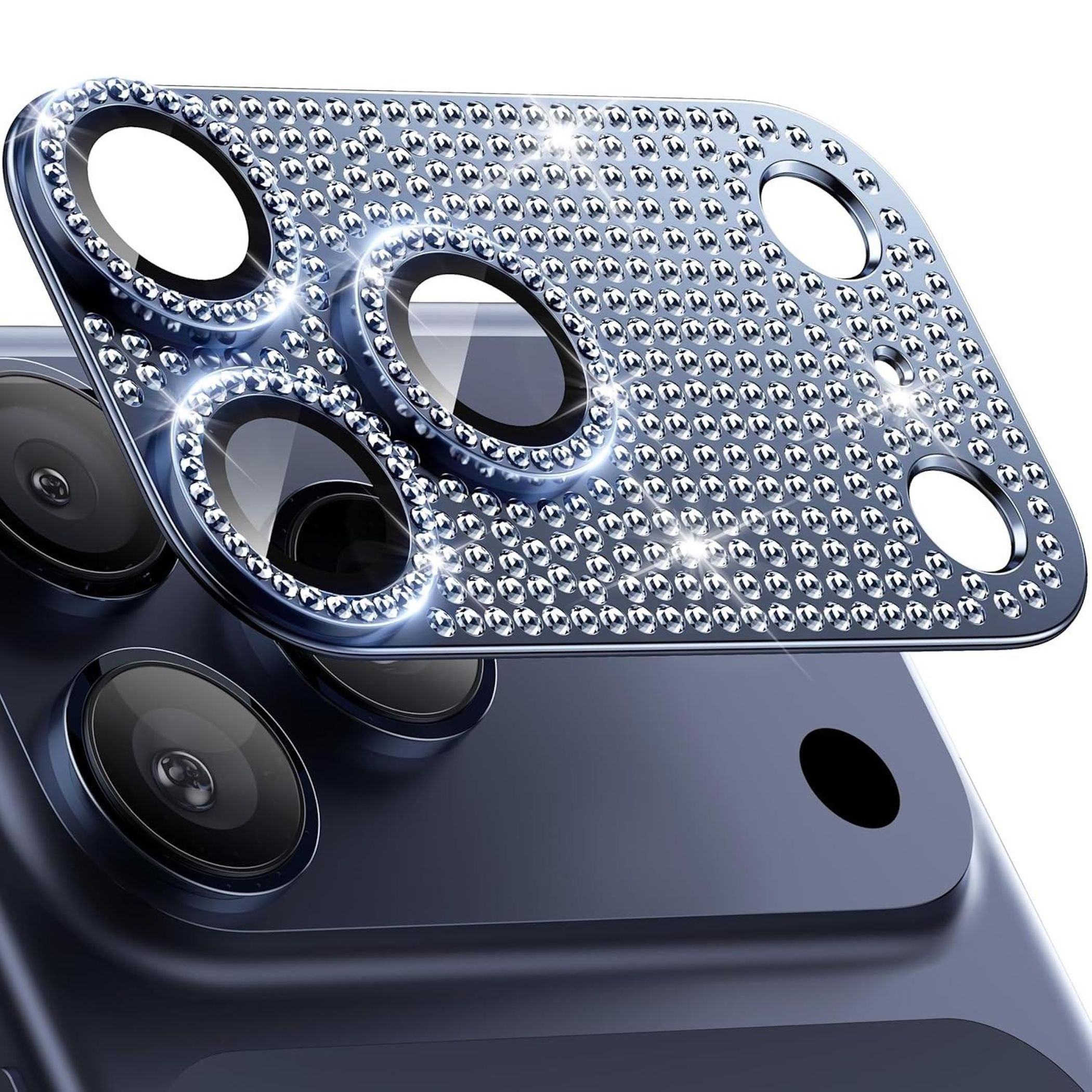 Primo piano di una protezione per l'obiettivo della fotocamera del telefono coperta da piccole gemme lucenti, su un telefono blu. Riflettente.