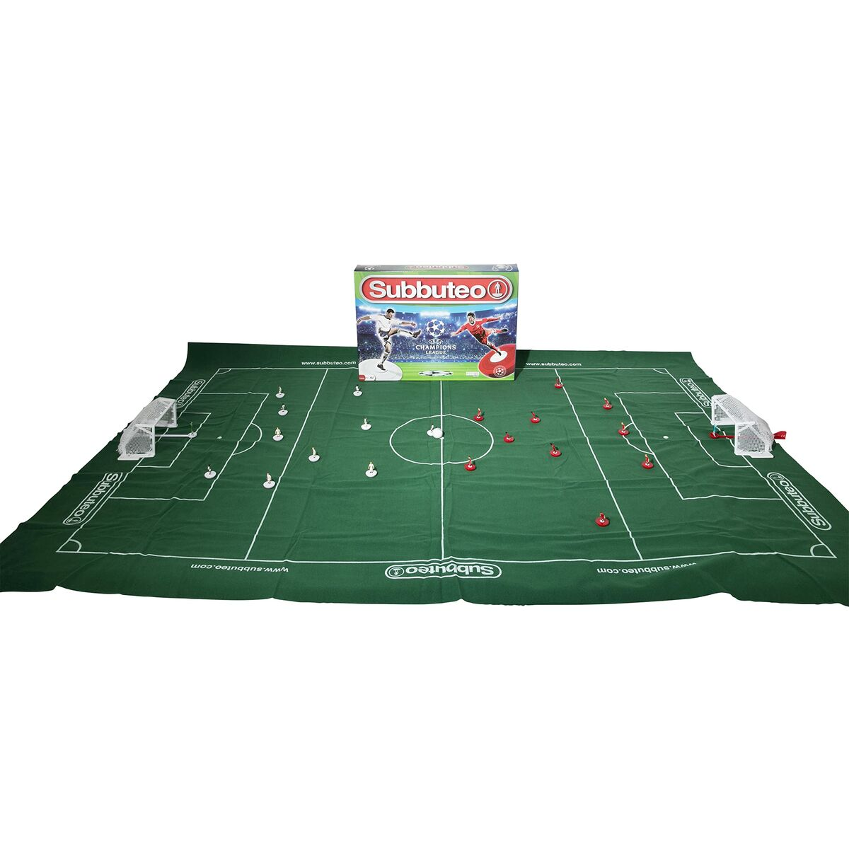 Una configuración del juego Subbuteo en un campo verde. Una caja del juego está en el centro. Hay líneas blancas, porterías y figuras rojas/blancas.