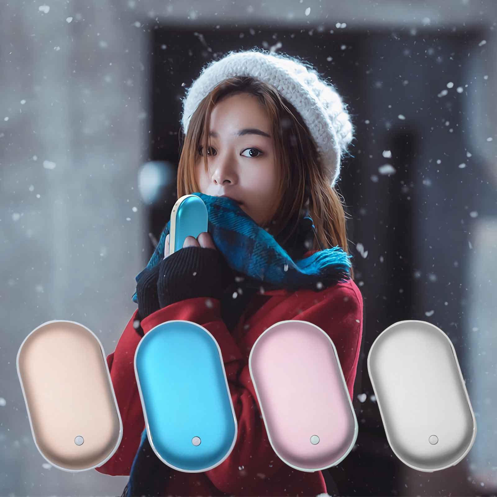 Eine Frau hält einen blauen Handwärmer, trägt einen weißen Hut und einen roten Mantel, während Schnee fällt. Vier Handwärmer werden angezeigt.
