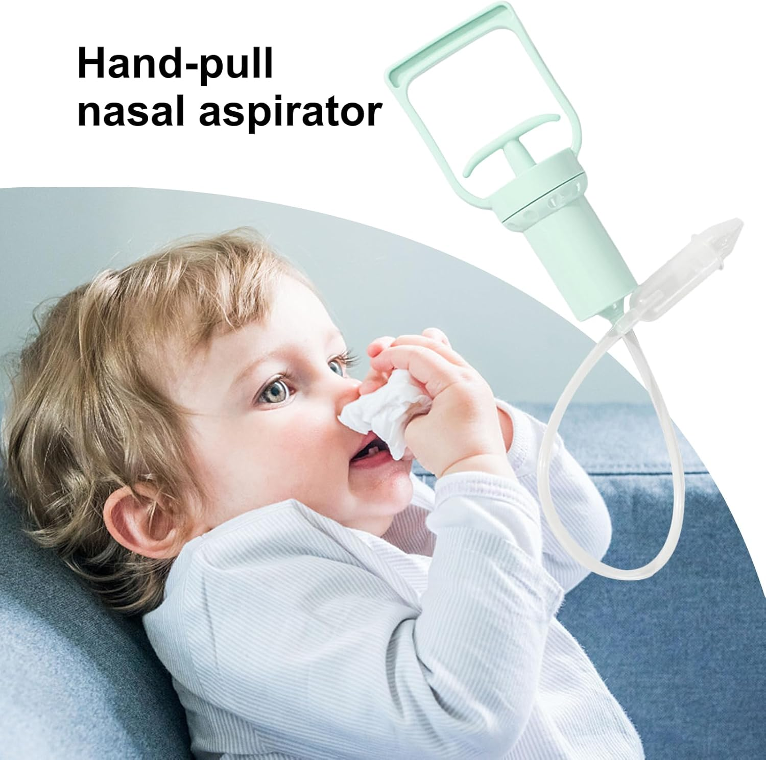 Ein Baby benutzt einen Nasensauger. Das Gerät ist hellgrün. Das Baby hält ein Taschentuch. Der Hintergrund ist ein blaues Sofa.