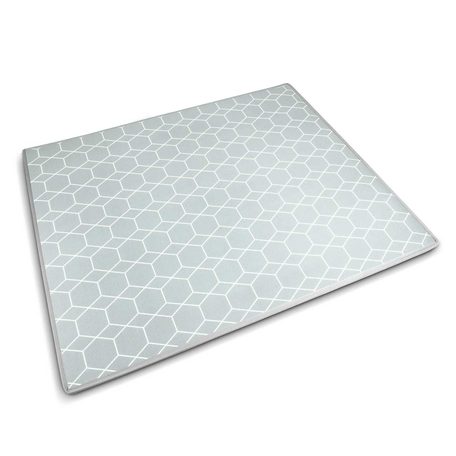 Una estera rectangular con un patrón geométrico de panal blanco sobre un fondo gris azul claro, con un borde blanco.