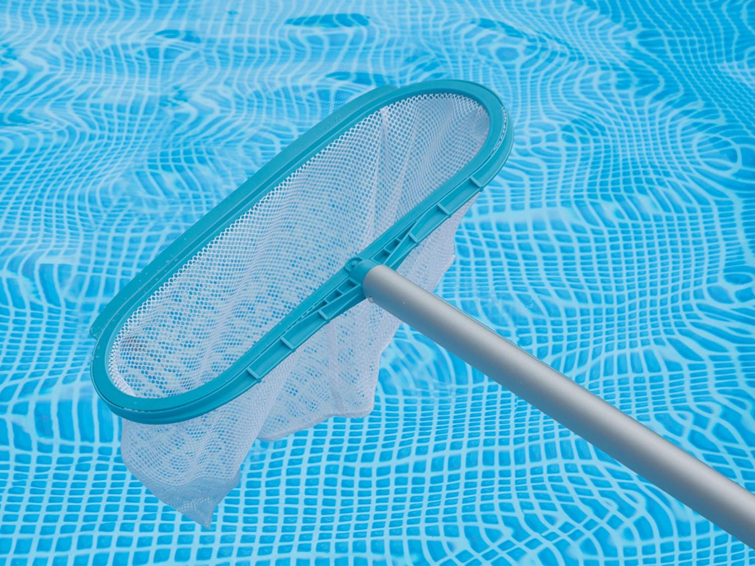 Una red de piscina con una malla blanca está en una piscina azul. La red tiene un marco turquesa y un mango gris.