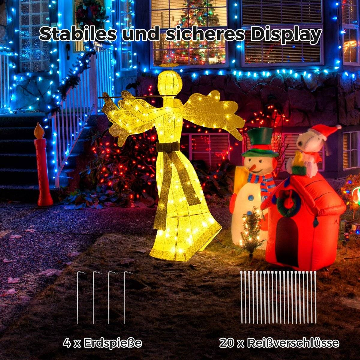Una decoración de ángel iluminado está en un jardín con luces navideñas y otras decoraciones.