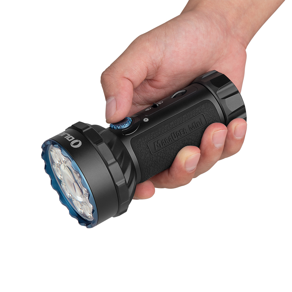 Eine Hand hält eine schwarze Taschenlampe. Die Taschenlampe hat eine blaue Lünette und die Aufschrift "Marauder Mini".