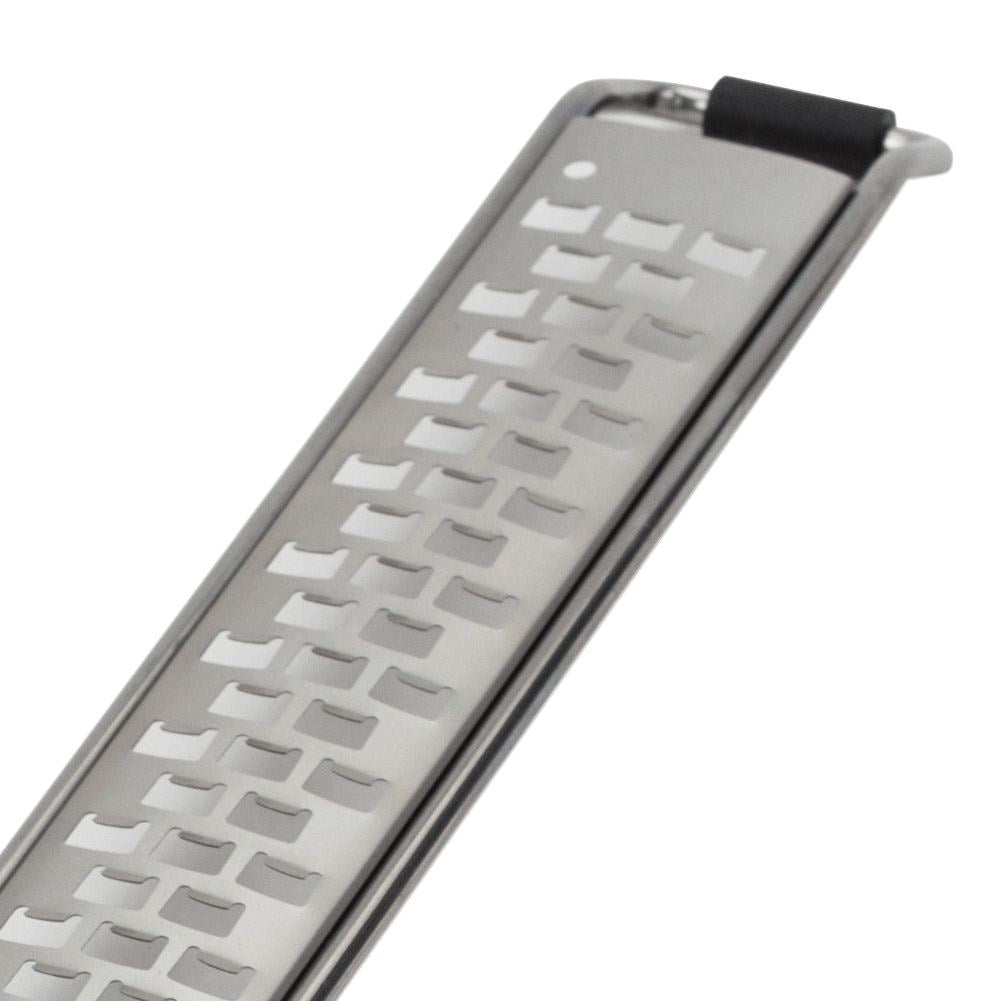 Primer plano de un rallador de acero inoxidable. El rallador tiene agujeros rectangulares. Hay un agarre de goma negro en la parte superior.