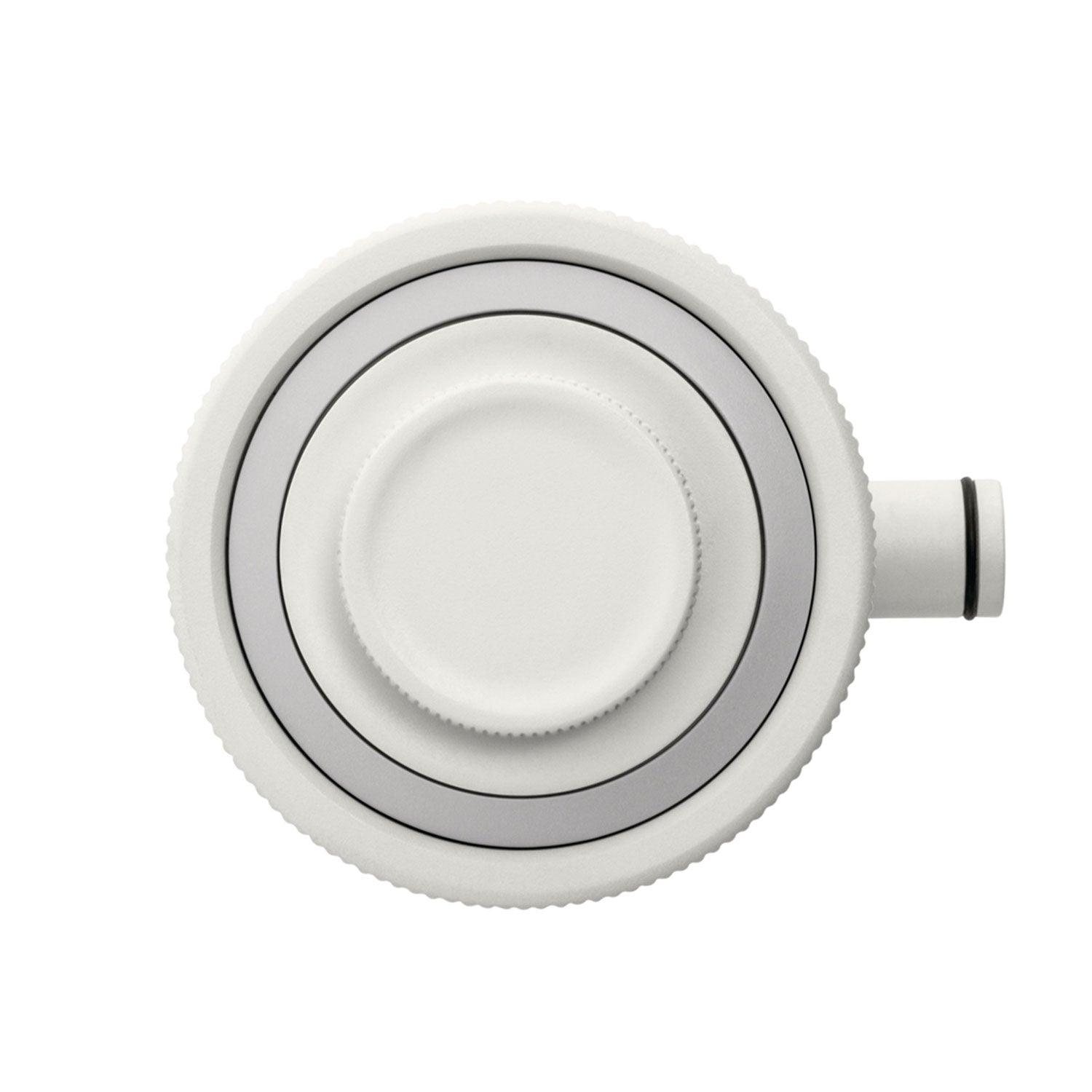 Vista superior de un dispositivo blanco con una perilla central, rodeada de anillos concéntricos en blanco y gris, y un tubo pequeño.