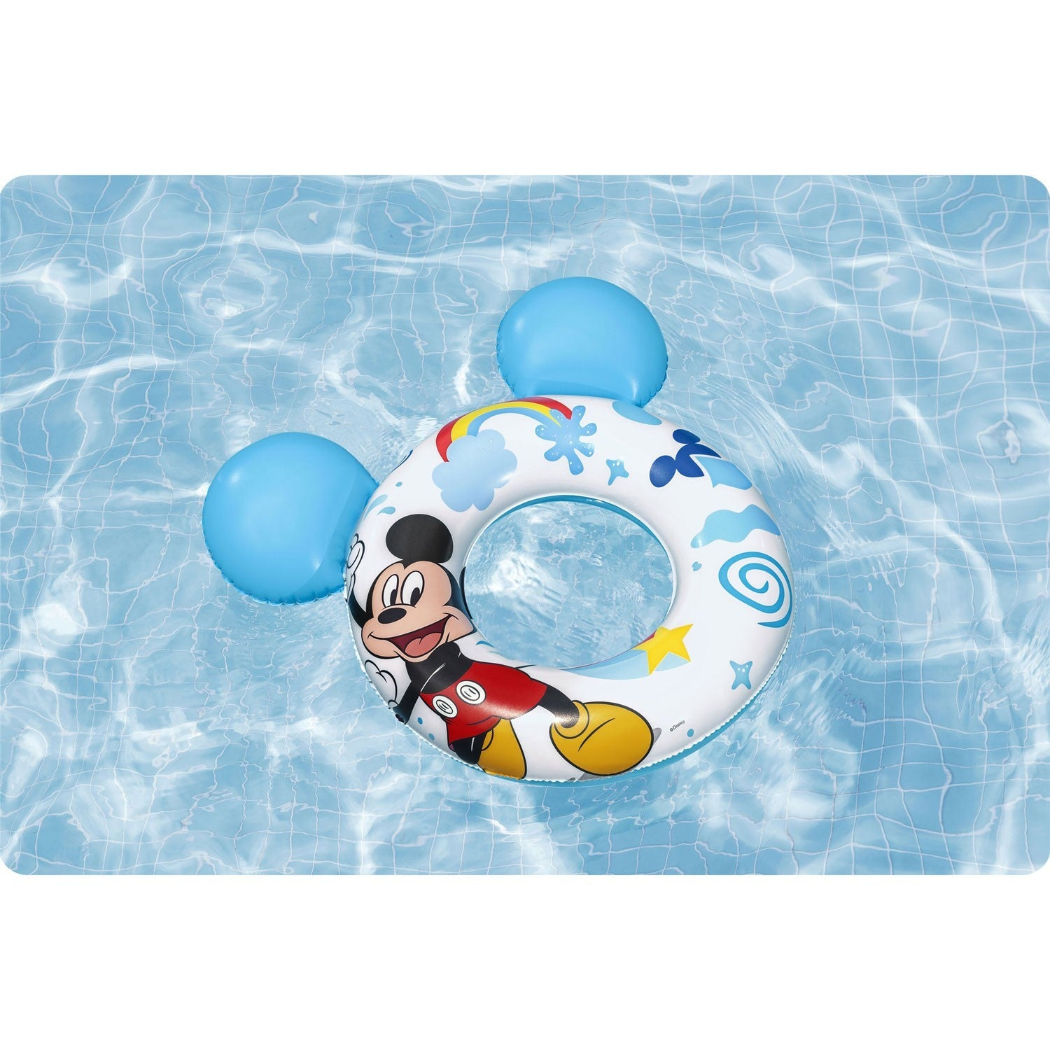 Un flotador inflable de Mickey Mouse flota en una piscina azul. El anillo tiene la cara y las orejas de Mickey. La piscina tiene un patrón de azulejos.