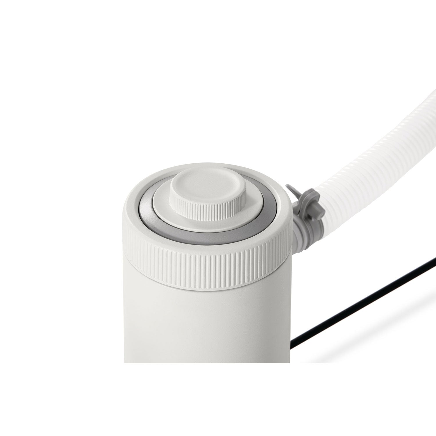 Un dispositivo cilíndrico blanco con una parte superior estriada y una manguera blanca conectada. Visible un cable negro. El fondo es blanco.