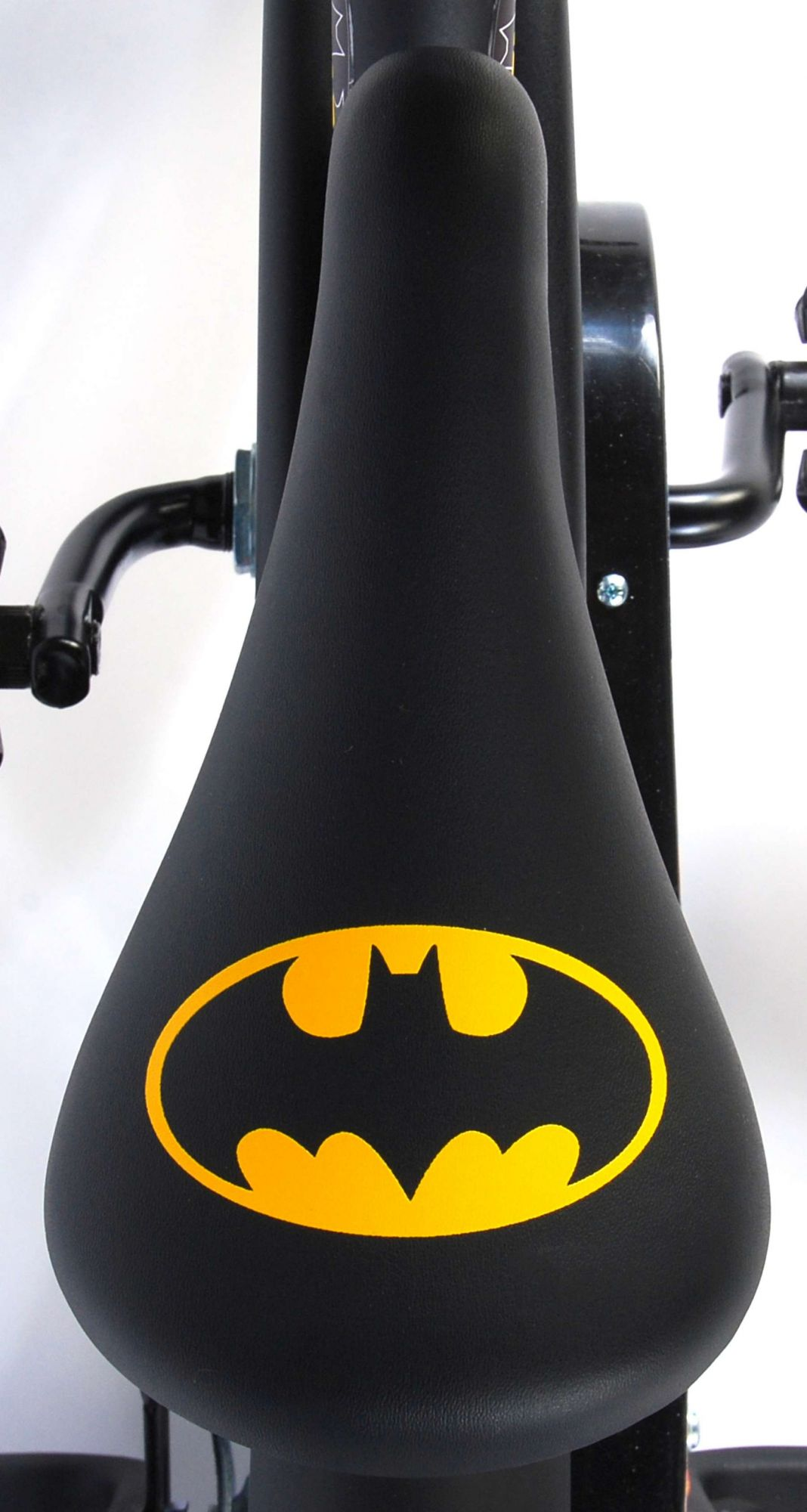 Schwarzer Fahrradsattel mit gelbem Batman-Logo. Der Sattel ist Teil eines schwarzen Heimtrainers, vor weißem Hintergrund.