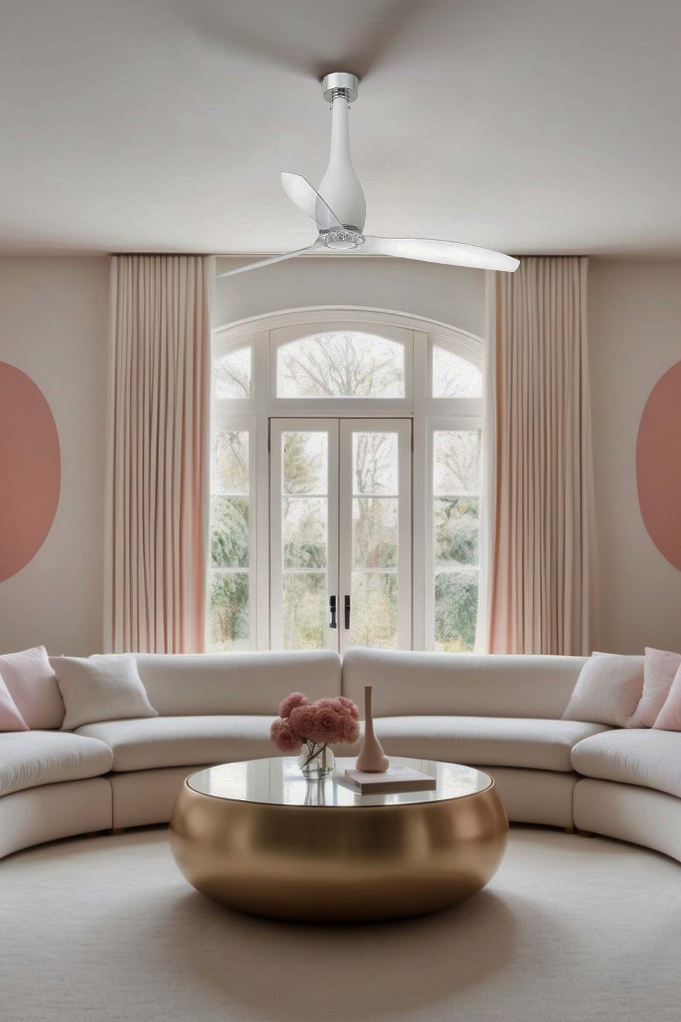 Modernes Wohnzimmer mit weißem Sofa, goldenem Couchtisch und Deckenventilator. Großes Fenster und rosa Akzente.