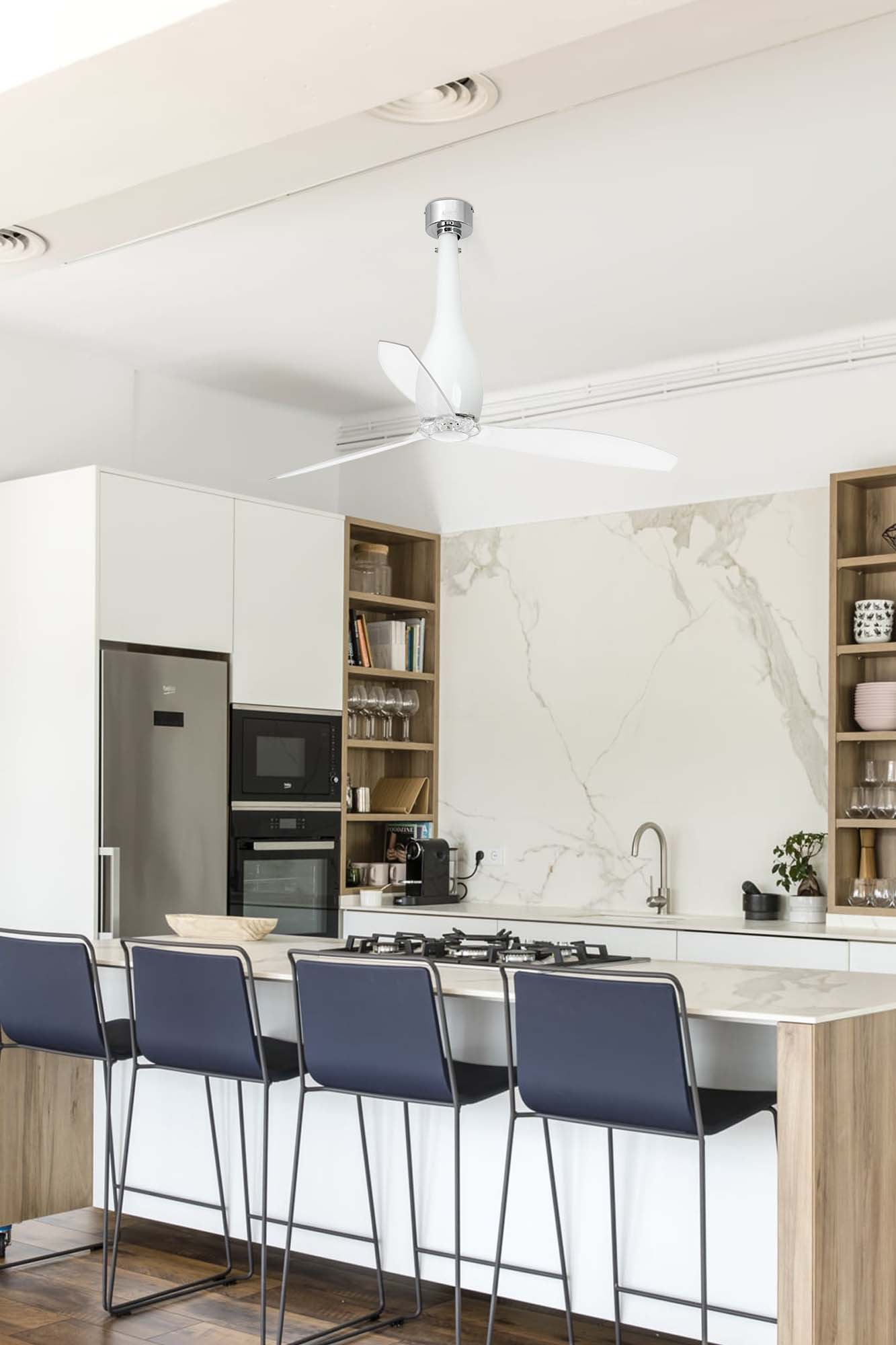 Moderne Küche mit Deckenventilator. Kücheninsel mit Barhockern, Geräten und weißen Schränken. Marmorwand.