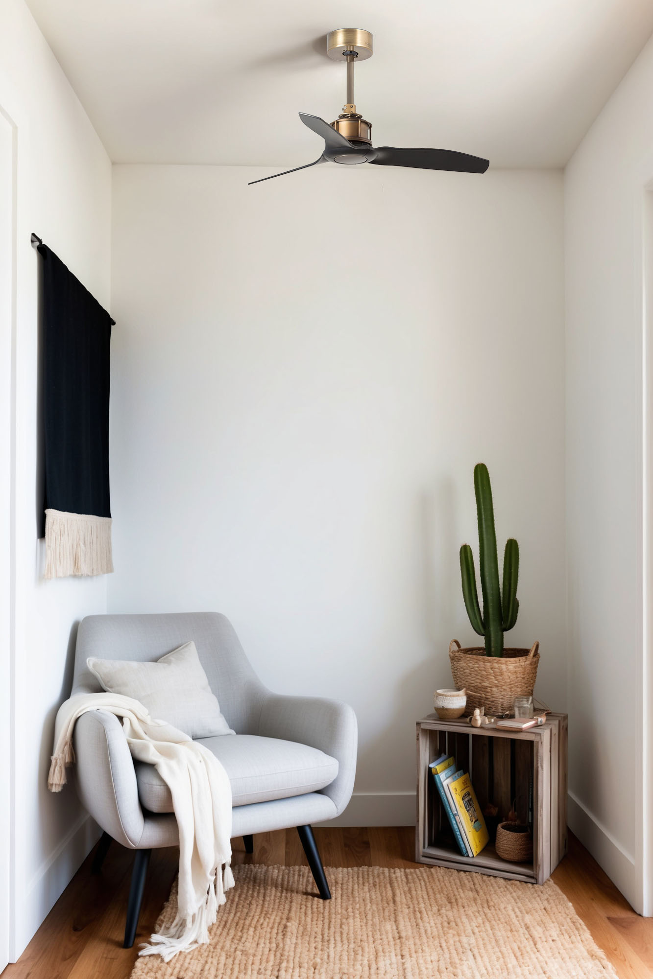 Ein Raum mit grauem Sessel, Kaktus und Holzkiste. Ein schwarzer Ventilator hängt an der Decke. Auf dem Boden liegt ein Teppich.