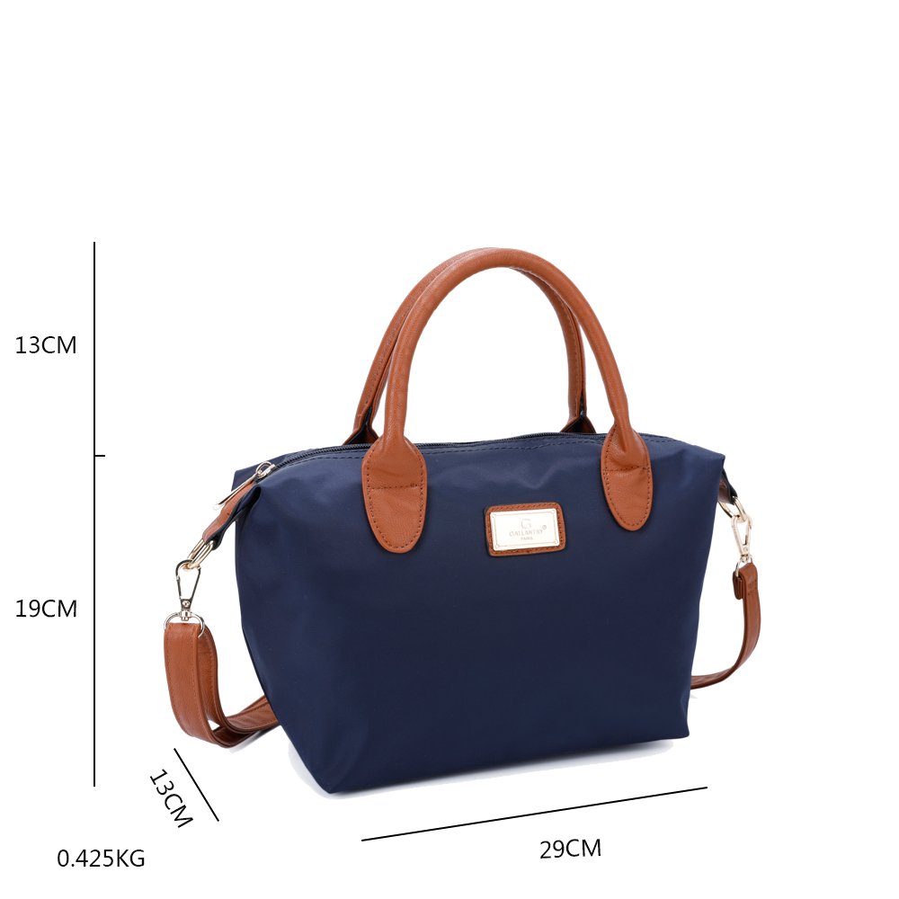 Eine marineblaue Handtasche mit braunen Henkeln und einem Schulterriemen. Die Tasche hat ein goldenes Etikett und befindet sich auf weißem Hintergrund.