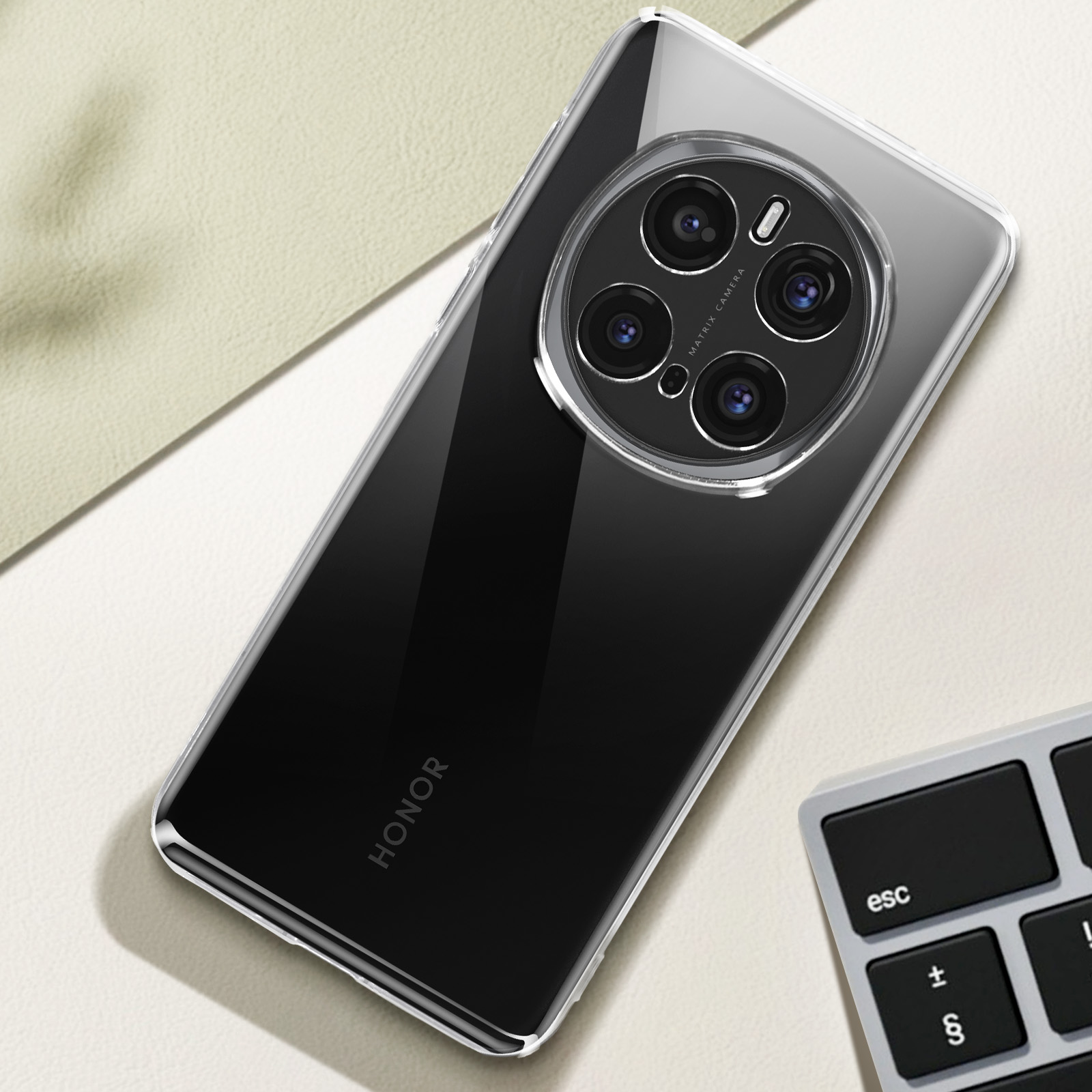 Un telefono in una custodia è appoggiato su una superficie chiara. Il telefono ha un sistema di fotocamera e la parola HONOR.