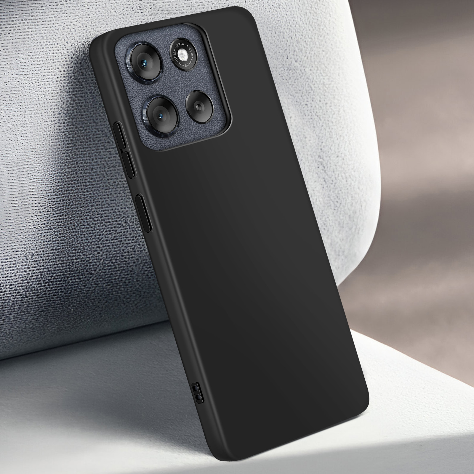 Zwarte telefoonhoes met cameralenzen, rustend op een witte, getextureerde ondergrond. Achtergrond neutraal.