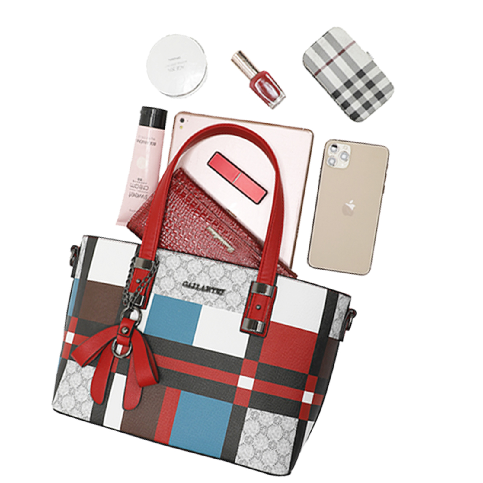 Un bolso tote estampado con asas rojas, rodeado de objetos como un teléfono, tableta, cartera, maquillaje y esmalte de uñas.
