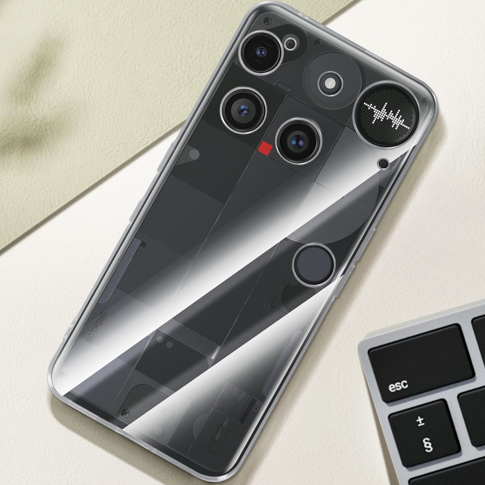 Un téléphone dans un étui transparent. Composants internes visibles. Un clavier en arrière-plan.