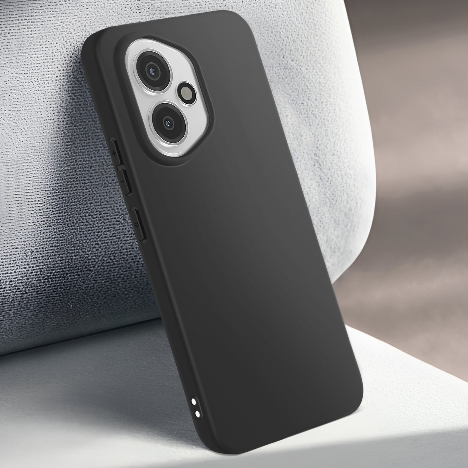 Una custodia nera per telefono con lenti della fotocamera è appoggiata a una superficie bianca strutturata, con sfondo marrone chiaro.