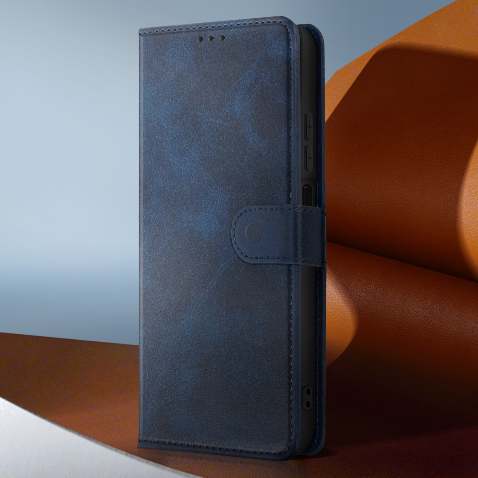 Una custodia per telefono in pelle blu chiusa, con chiusura a bottone. Lo sfondo è un mix di arancione e blu.
