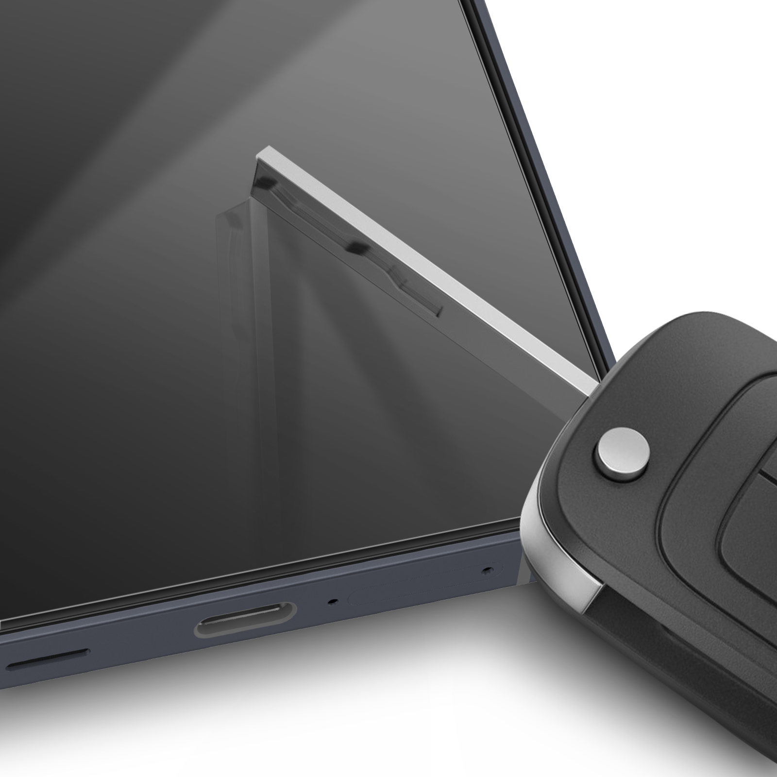 Uno smartphone e un portachiavi nero sono su una superficie bianca. Il telefono è grigio scuro.