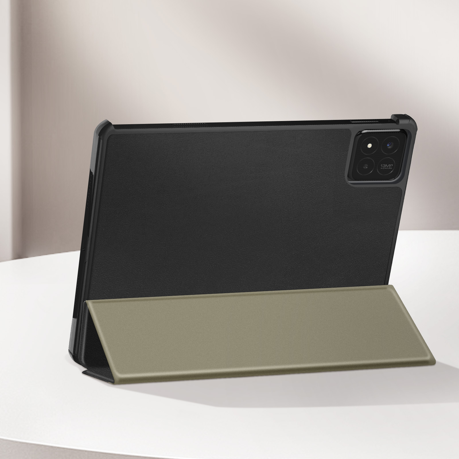 Tablet in custodia nera con cover verde oliva, appoggiato su una superficie bianca. Lo sfondo è neutro.