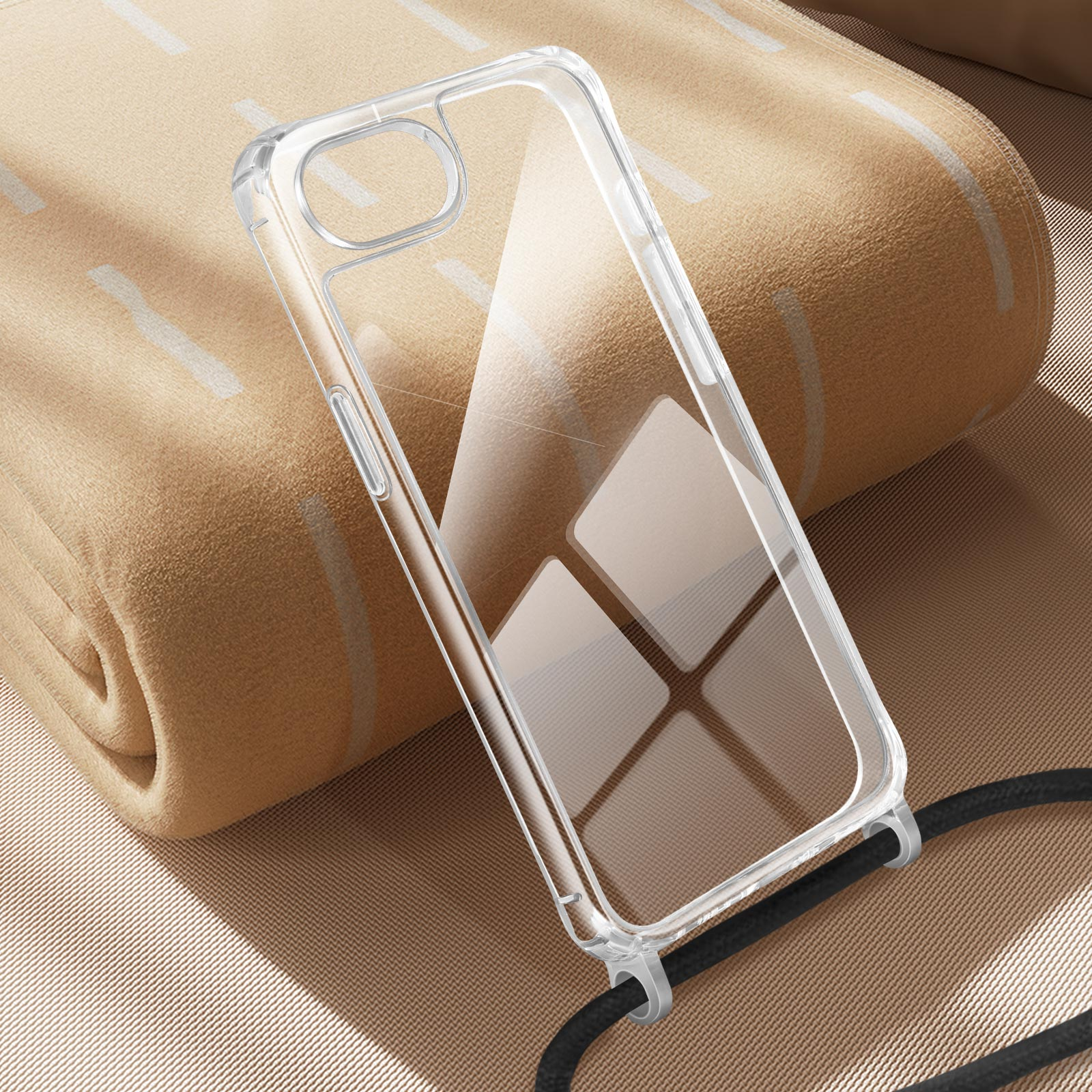 Un étui de téléphone transparent avec un cordon noir repose sur une couverture beige.