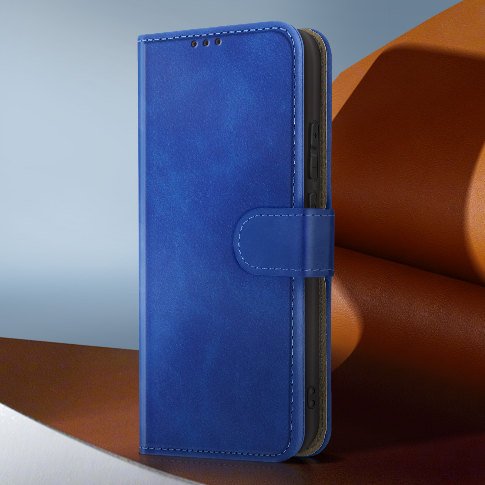 Custodia blu per telefono con chiusura magnetica, che protegge un telefono nero. Lo sfondo ha sfumature marroni e blu.