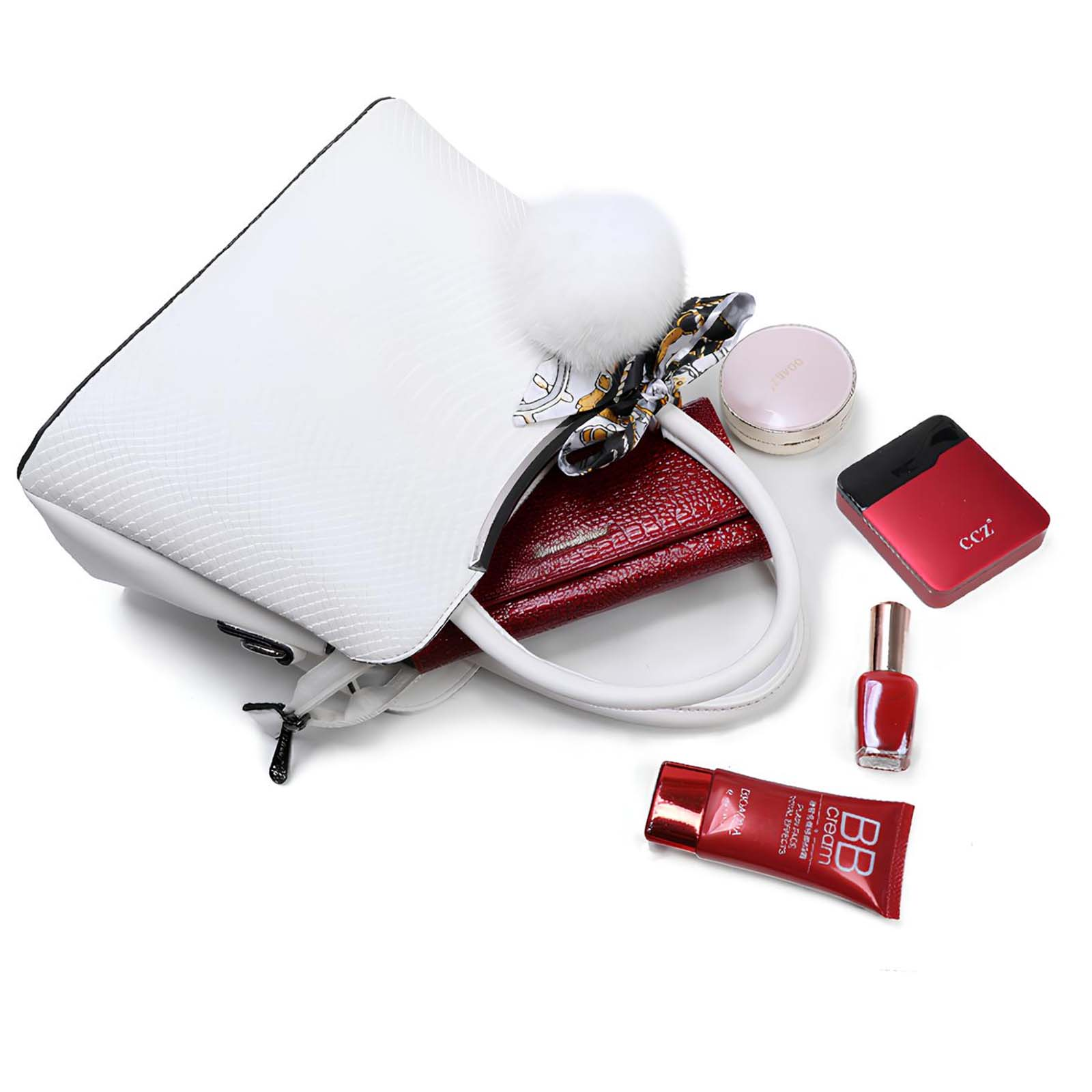 Bolso blanco con accesorios: cartera, maquillaje y esmalte de uñas sobre una superficie blanca. Un pompón blanco está adjunto.